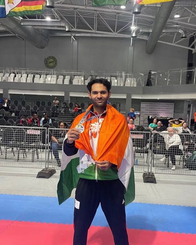 Akshay Mahara with the Indian flag and a medal